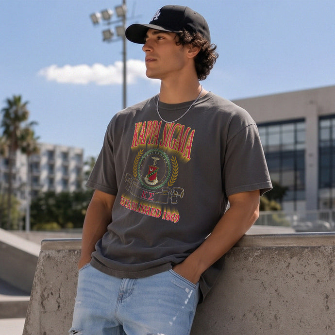 College-aged male wearing the fraternity Collegiate Crest Graphic Tee in charcoal grey, featuring vintage Kappa Sigma crest artwork on campus.