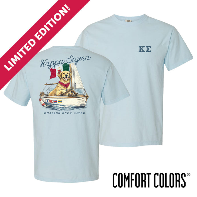 Light blue Comfort Colors t-shirt shown front and back; front features small Greek letters on the left chest, back displays a golden retriever sailing a boat with script text above and “Chasing Open Water” below.