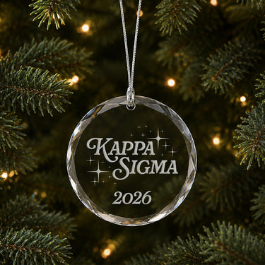 Limited Edition glass Christmas ornament with engraved design hanging on a decorated holiday tree