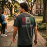 College student wearing fraternity grey t-shirt with colorful flag design on back