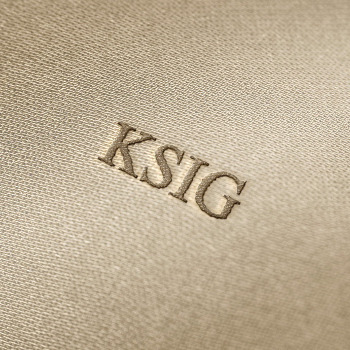 Soft beige fabric close-up showing a smooth, heavyweight knit texture with gentle folds and subtle draping.