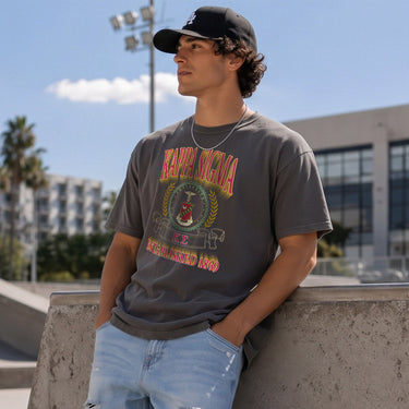 College-aged male wearing the fraternity Collegiate Crest Graphic Tee in charcoal grey, featuring vintage Kappa Sigma crest artwork on campus.