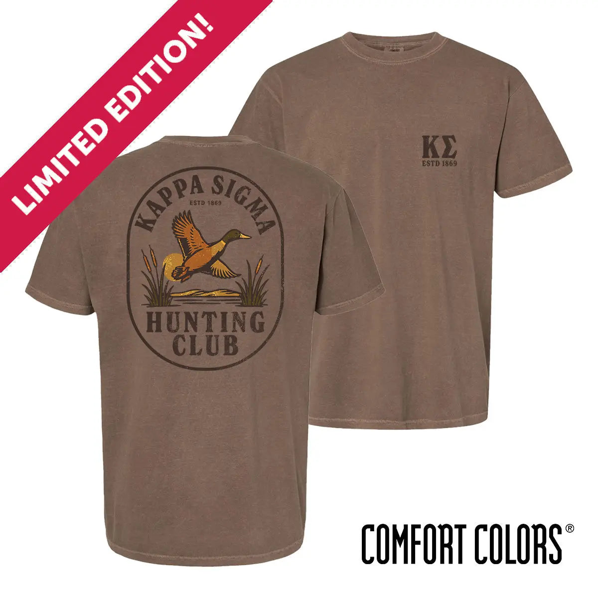 Brown garment-dyed short-sleeve tee featuring a vintage-inspired graphic: a weathered oval frames a mallard in mid-flight with burnt orange and mossy green-tipped wings above rippling water and cattails; distressed Kappa Sigma arcs overhead and Kappa Sig letters bold and rugged on the front.